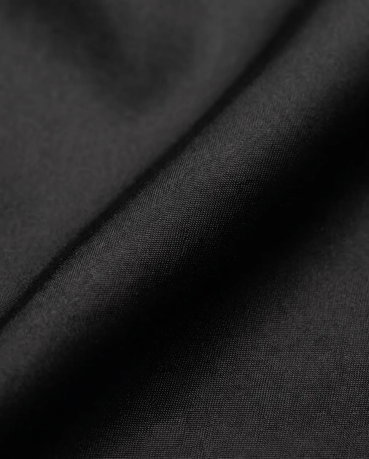 Detalhe do tecido tactel corta-vento da calça baggy preta