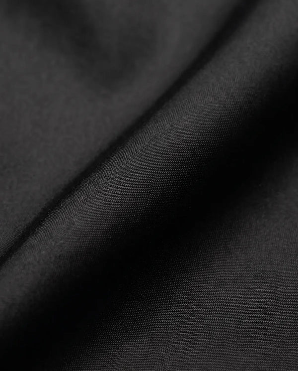 Detalhe do tecido tactel corta-vento da calça baggy preta