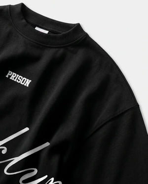 Detalhe da gola canelada e do ombro caído da camiseta oversized preta Prison