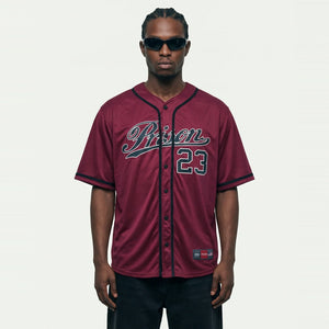 Jhon-1 veste a Camisa de Baseball Jersey 23 Vinho PRISON® de frente, com estampa Prison e 23 de contorno claro, calça preta e óculos escuros.