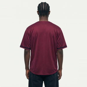Jhon-1 veste a Camisa de Baseball Jersey 23 Vinho PRISON® de costas, sem estampa, com acabamentos pretos nas mangas e calça preta.