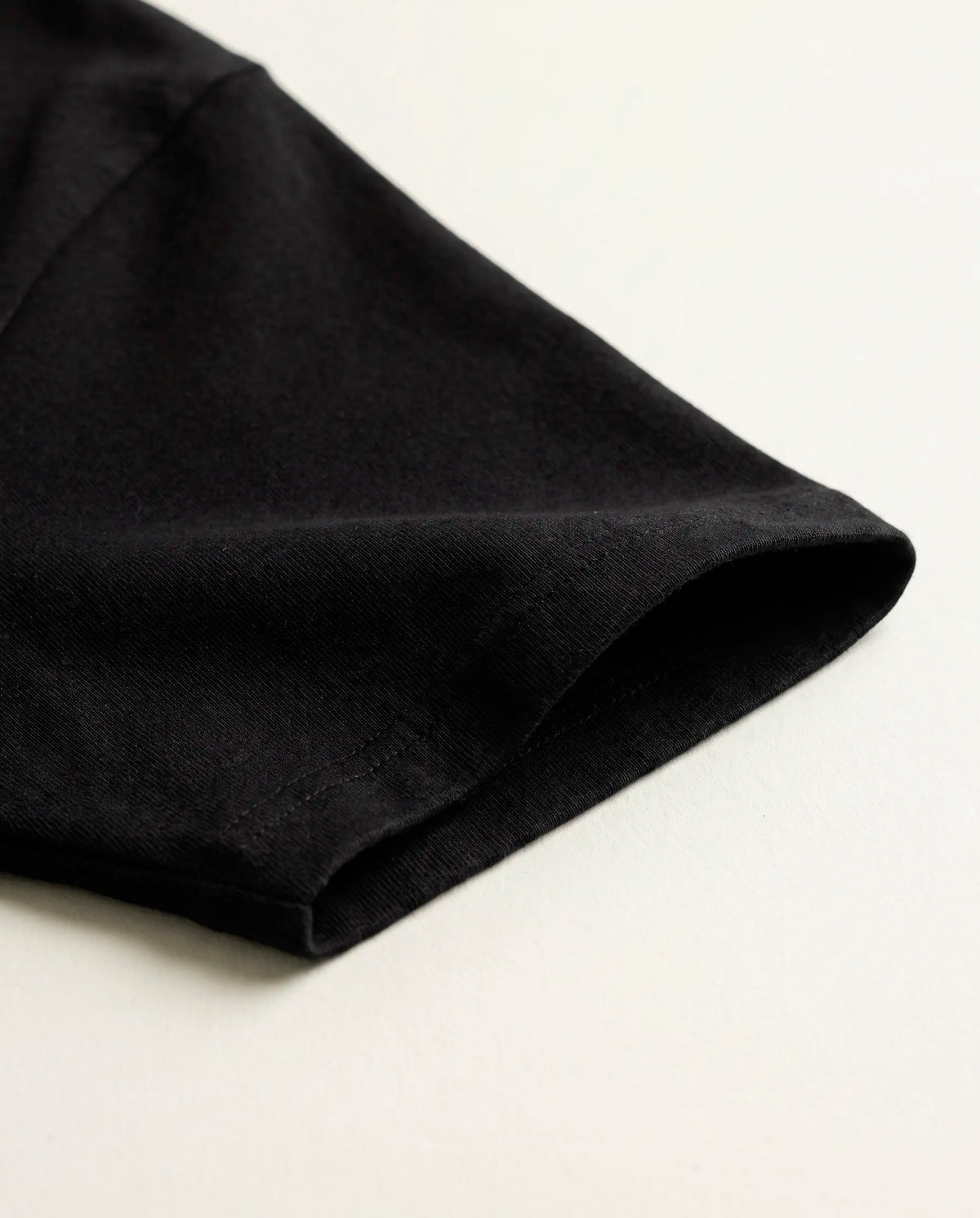 Detalhe da manga e da malha de algodão da camiseta oversized Darkness Prison preta.