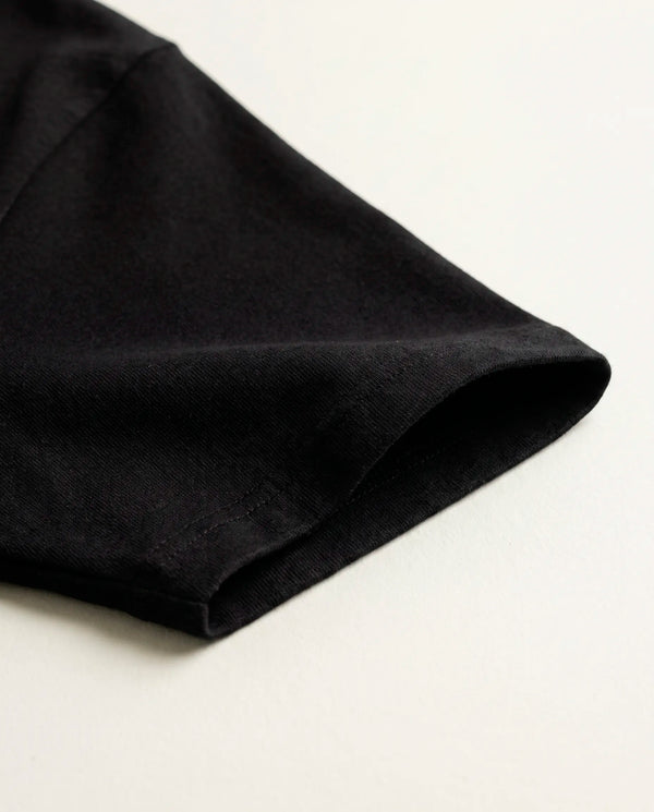Detalhe da manga e da malha de algodão da camiseta oversized Darkness Prison preta.