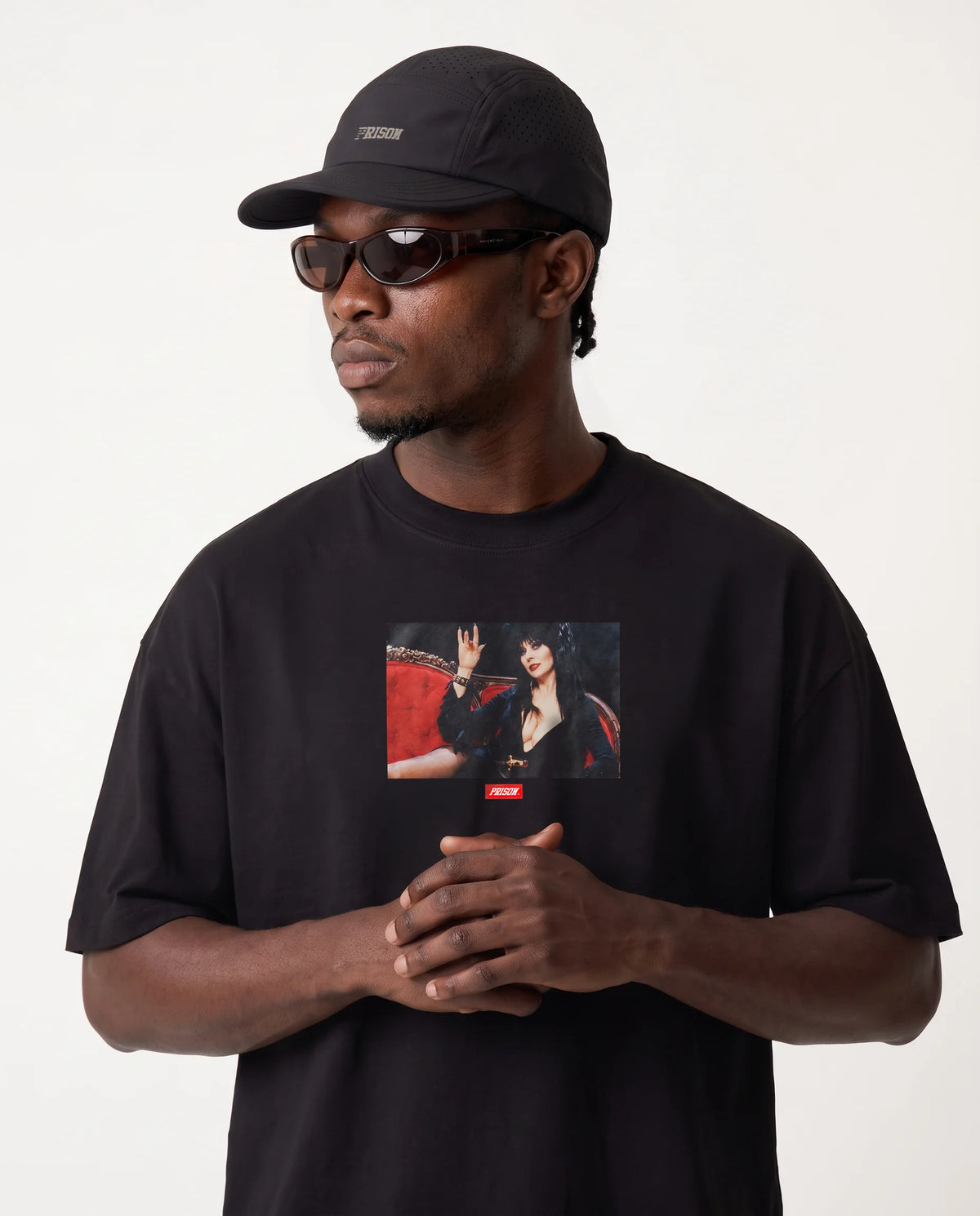 Modelo vestindo a camiseta oversized Darkness Prison preta com print vermelho.