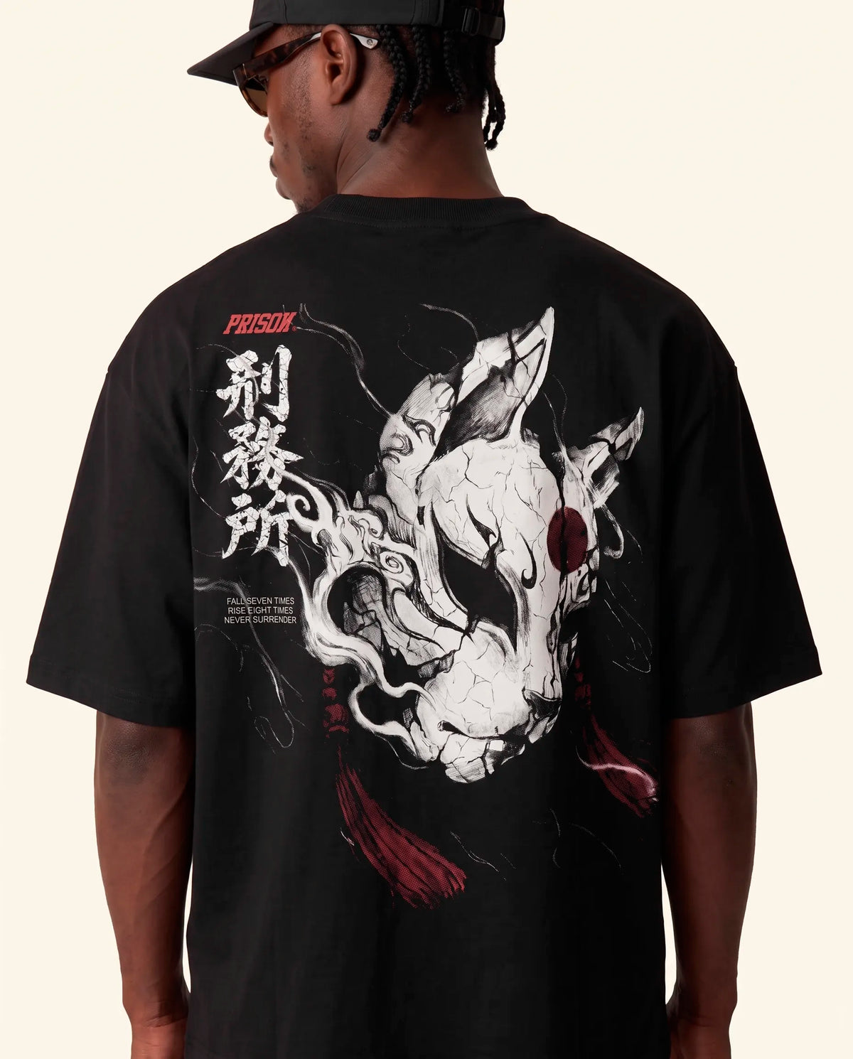 Modelo de costas mostrando a estampa da raposa na camiseta oversized Kitsune Prison preta.