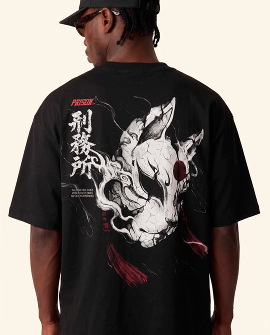 Modelo de costas mostrando a estampa da raposa na camiseta oversized Kitsune Prison preta.
