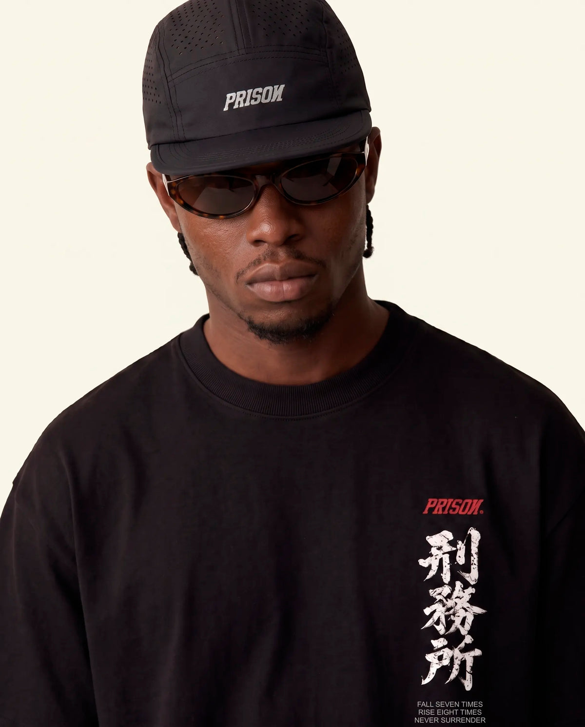 Modelo vestindo a camiseta oversized Kitsune Prison preta, vista frontal do caimento amplo.