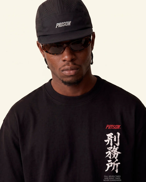 Modelo vestindo a camiseta oversized Kitsune Prison preta, vista frontal do caimento amplo.