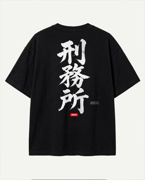Costas da camiseta oversized Kanji Ink Prison preta com caligrafia em pincel branco e selo vermelho.