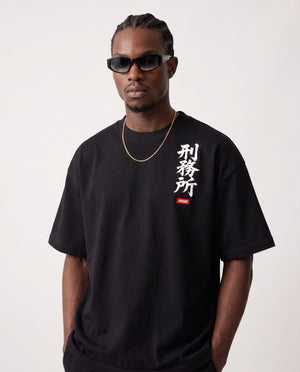 Modelo vestindo a camiseta oversized Kanji Ink Prison preta, vista de frente.