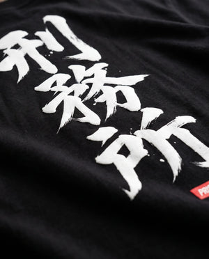 Detalhe da caligrafia em pincel branco com selo vermelho nas costas da camiseta oversized Prison.