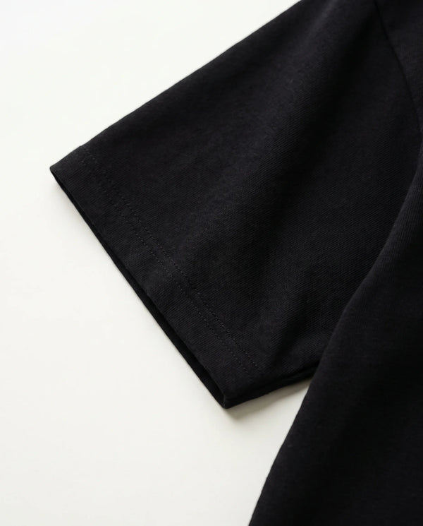 Detalhe da manga e da malha de algodão da camiseta oversized Kanji Ink Prison preta.