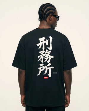 Modelo de costas com a caligrafia japonesa da camiseta oversized Kanji Ink Prison.