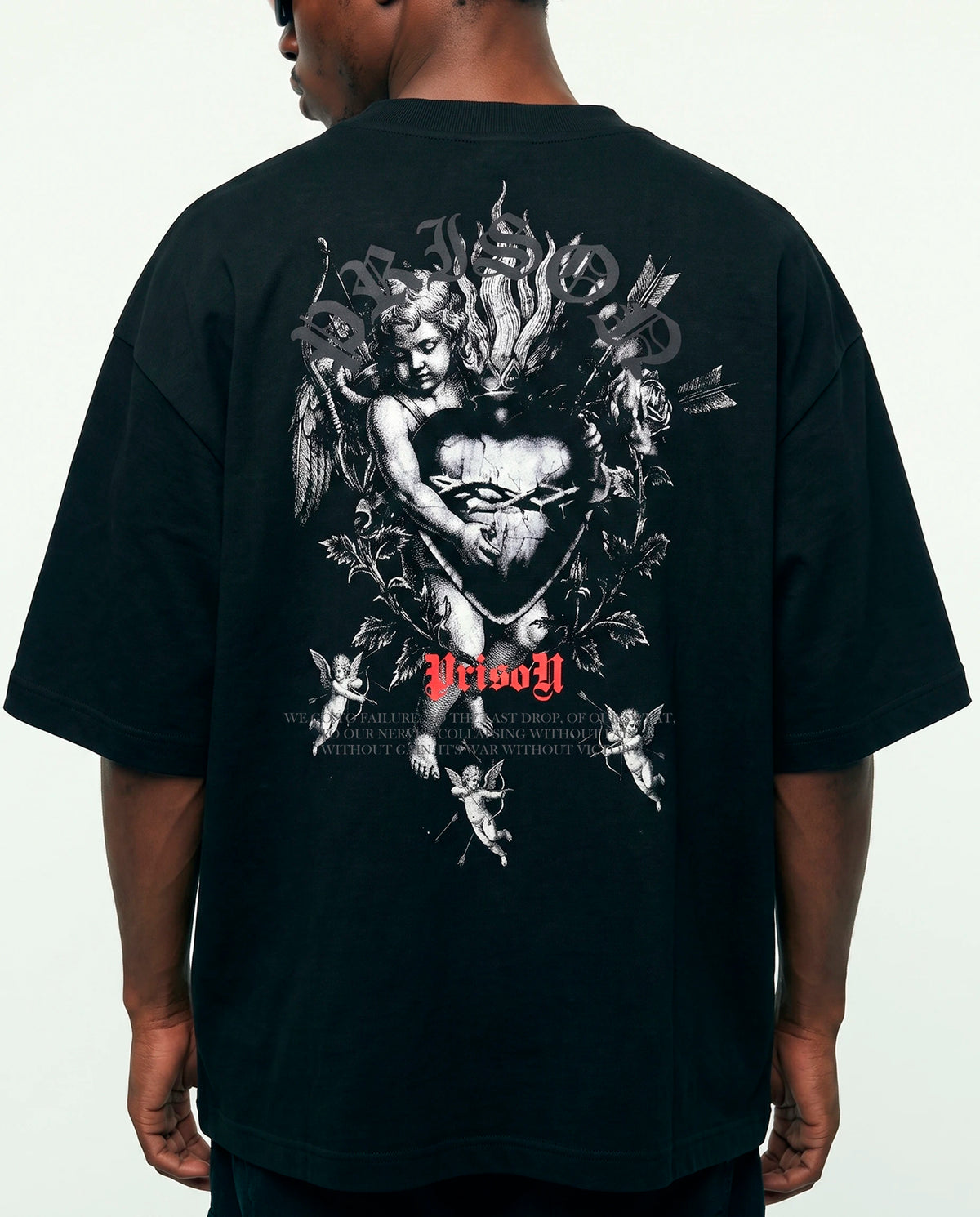 Modelo de costas com a arte de querubins da camiseta oversized Angel Prison preta.