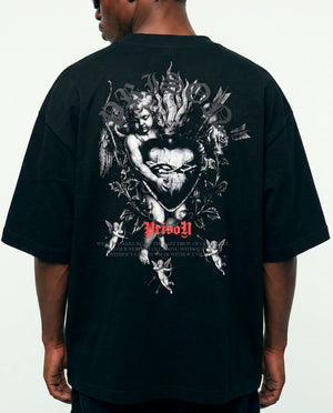 Modelo de costas com a arte de querubins da camiseta oversized Angel Prison preta.