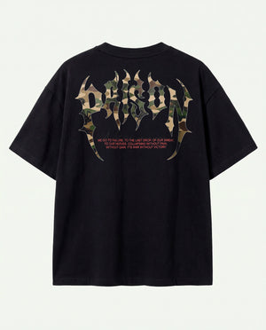 Costas da camiseta oversized Camuflada Core Prison com padrão camuflado e flores vermelhas.
