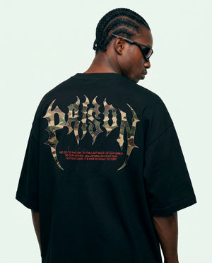 Modelo de costas mostrando o camuflado com gótico Prison da camiseta oversized preta.