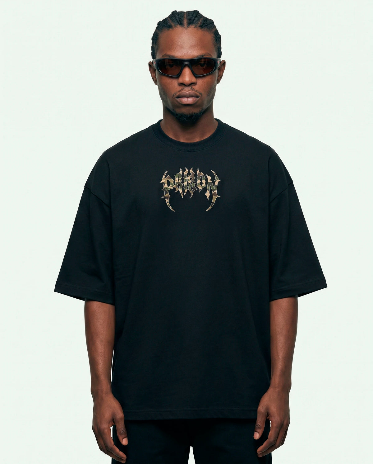 Modelo vestindo a camiseta oversized Camuflada Core Prison preta, vista frontal.