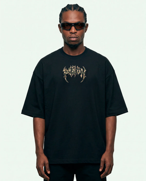 Modelo vestindo a camiseta oversized Camuflada Core Prison preta, vista frontal.