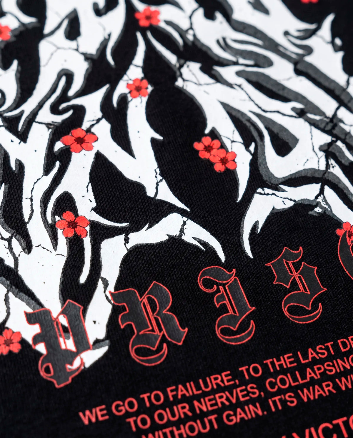 Detalhe do texto em vermelho e do gótico Prison na camiseta oversized Only Victories.