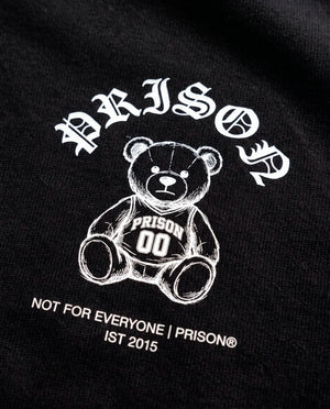 Detalhe da assinatura Not For Everyone e do urso no peito da camiseta oversized Prison preta.