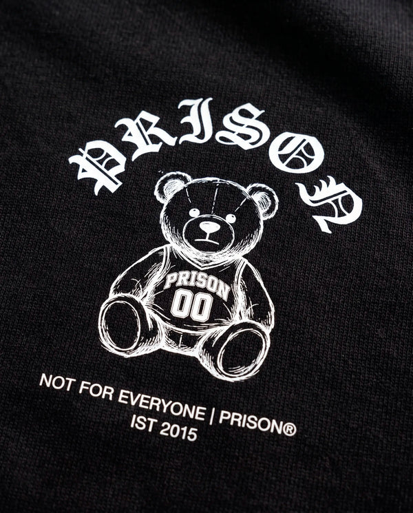 Detalhe da assinatura Not For Everyone e do urso no peito da camiseta oversized Prison preta.