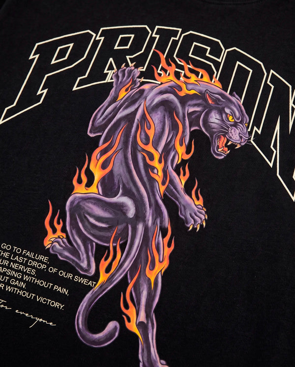Detalhe da pantera em chamas roxa e laranja na camiseta oversized Prison preta.