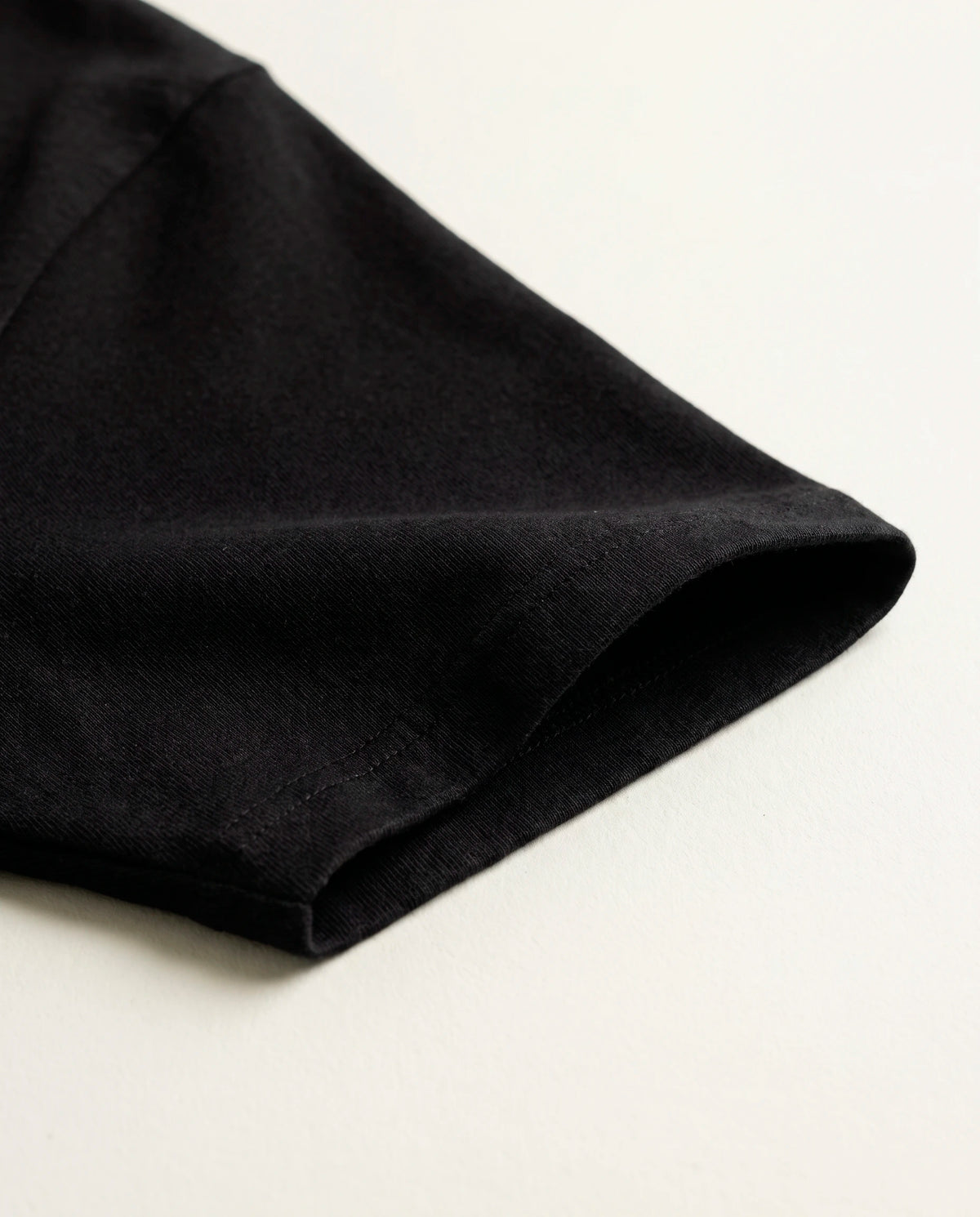 Detalhe da manga e do tecido de algodão da camiseta oversized Panther Fire preta.