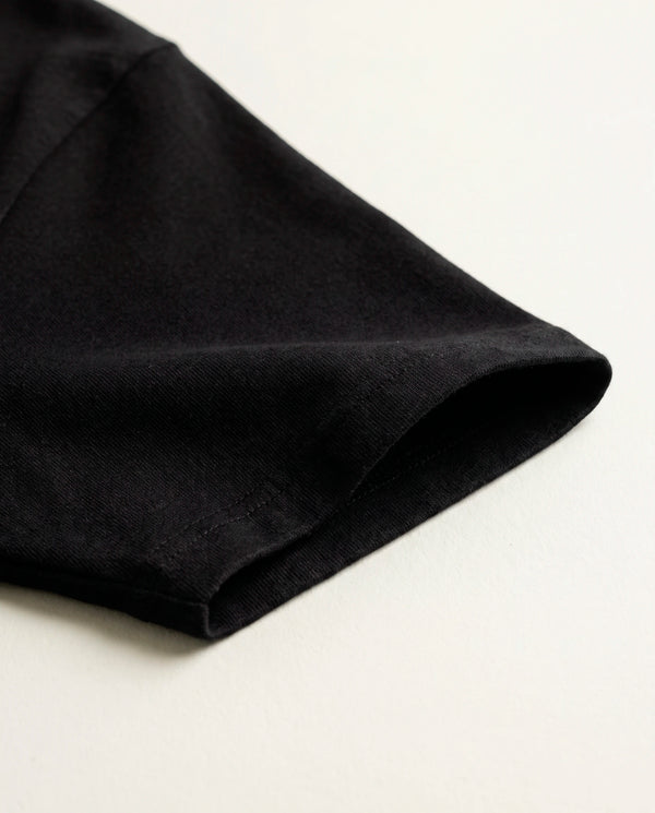 Detalhe da manga e do tecido de algodão da camiseta oversized Panther Fire preta.