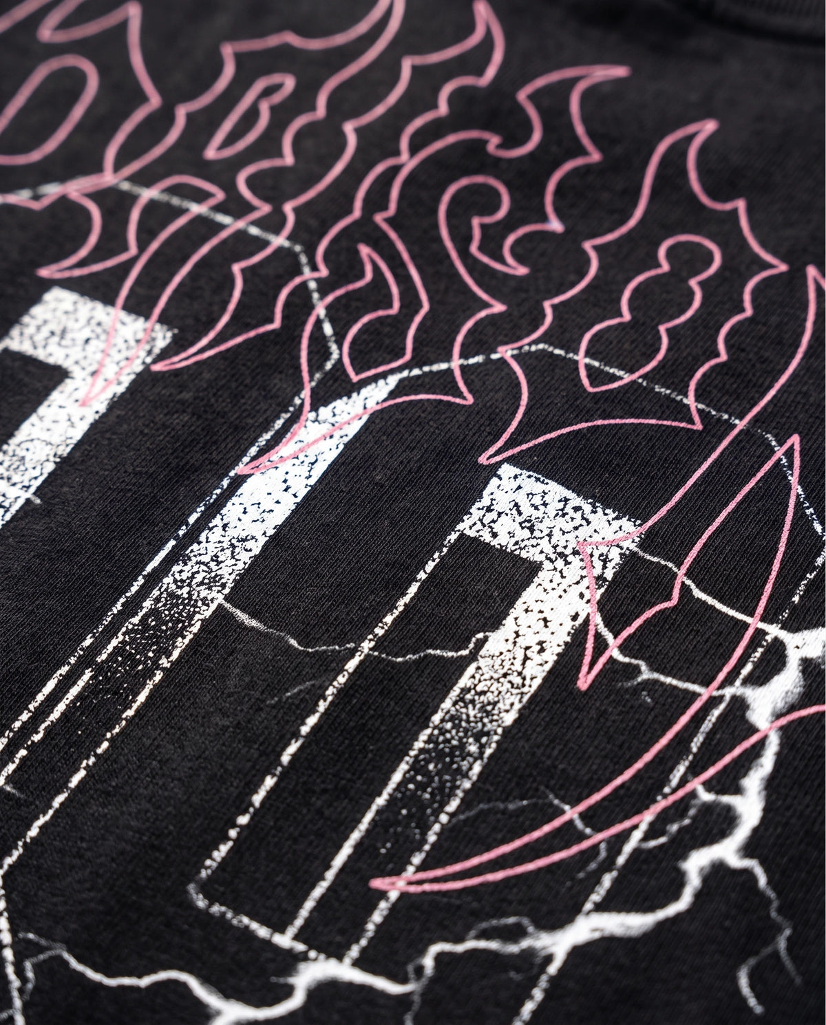 Detalhe ampliado do logo em estilo metal nas costas da camiseta oversized Thunder preta.