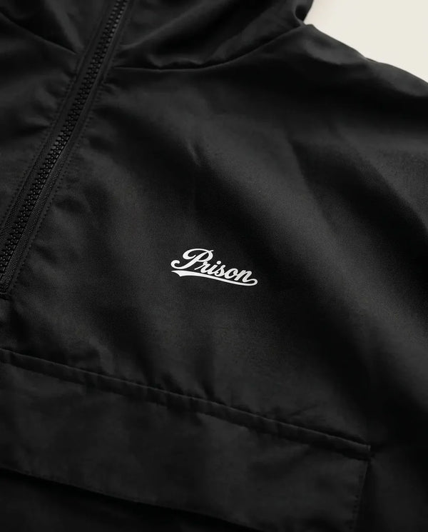 Detalhe do logo PRISON na jaqueta corta-vento masculina preta