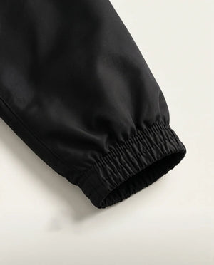 Detalhe do punho elástico da jaqueta corta-vento masculina preta Prison