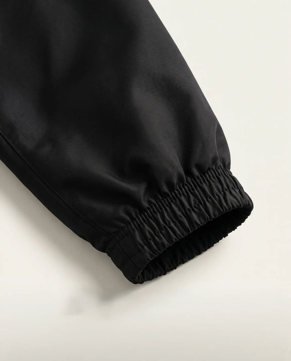 Detalhe do punho elástico da jaqueta corta-vento masculina preta Prison