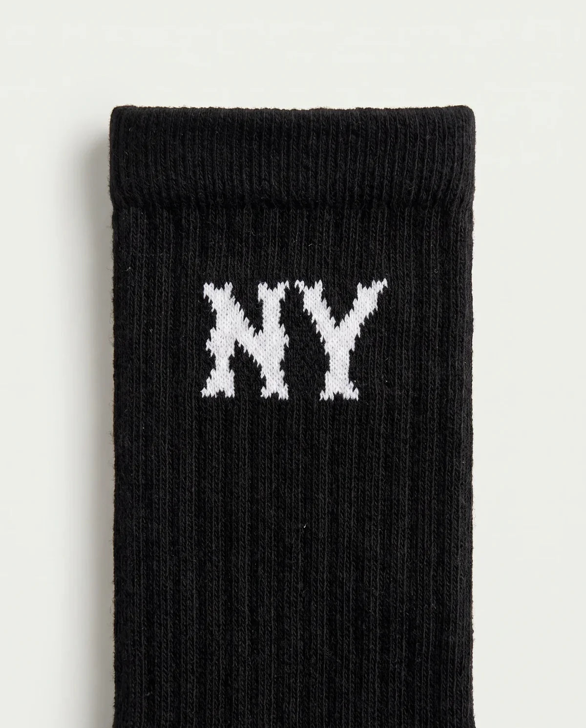 Detalhe do lettering NY no cano da meia masculina preta Prison