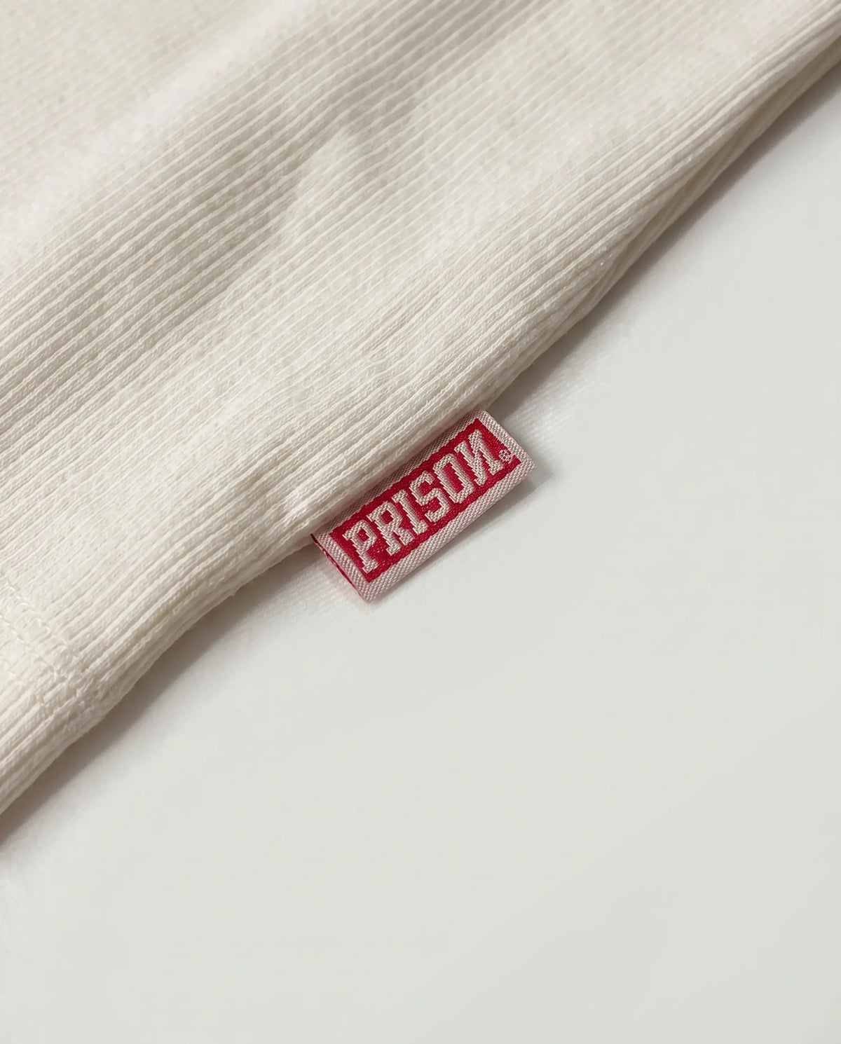 Etiqueta oficial PRISON na regata canelada off white