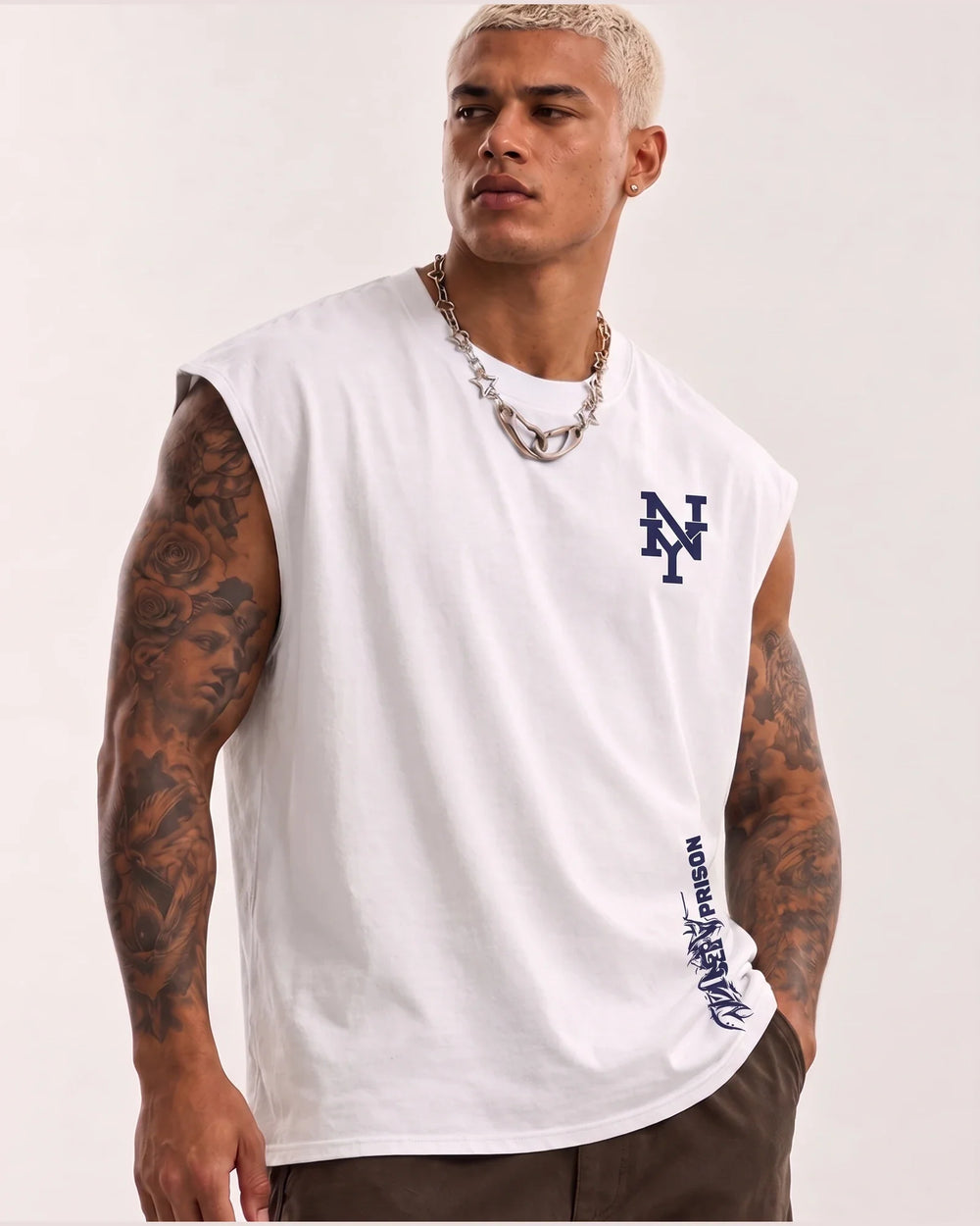 Modelo usando a Regata Machão Tribal NY branca PRISON®, com monograma NY e arte tribal posicionados à direita na vista frontal.
